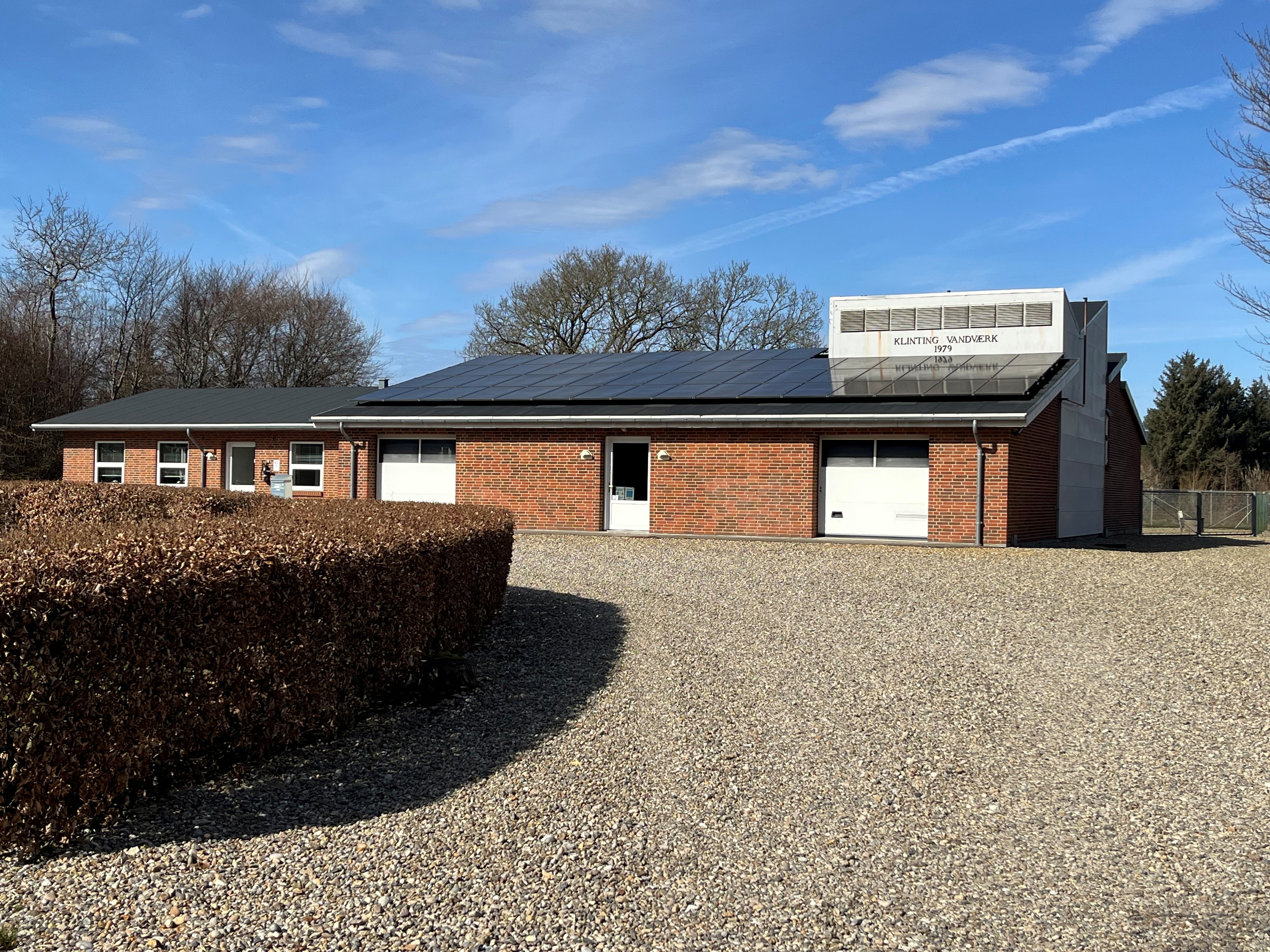 Lerpøt vandværk - Rød bygning med to hvide biler foran.